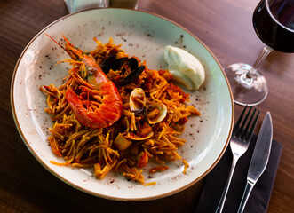 Freshly made fideua with assorted seafoods garnished with alioli sauce