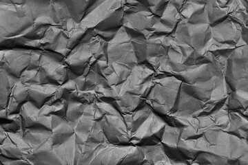 A textured gray crumpled paper background with natural creases and folds. Ideal for design projects, digital graphics, or creative presentations requiring a vibrant.