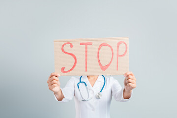 Healthcare professional holding a stop sign to promote awareness and support in a medical context