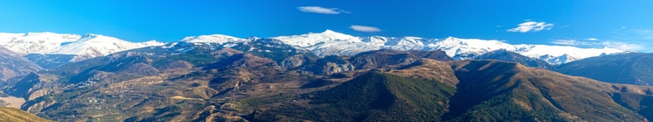Fototapeta premium Snowy Andalucian Sierra Nevada Mountain Range Scenic Landscape Panorama View. Hiking Llano de la Perdiz Natural Parkland Granada Blue Skyline