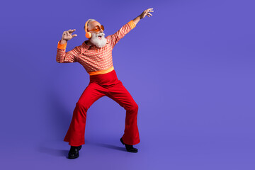 Retro themed smiling elderly gentleman dancing with enthusiasm in bold vintage attire against a vibrant purple backdrop