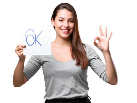 A young woman holding a card with a smiley face and making an -OK- sign, isolated on a transparent background PNG