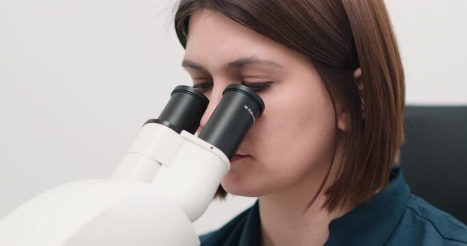  A laboratory technician performs microscope examinations in a modern medical laboratory. The concept of biochemistry and the sciences.                   