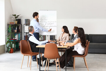 Male lawyer near flipchart and colleagues working in office