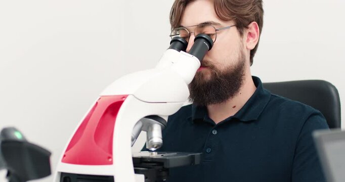  A laboratory technician performs microscope examinations in a modern medical laboratory. The concept of biochemistry and the sciences.                   