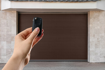Woman using remote to control garage door outdoors, closeup