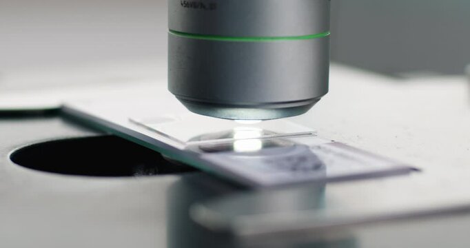Close-up of scientific microscope with glass, analyzing data in lab, research for vaccine production. Concept of biological sciences and virology. 