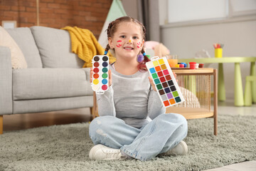 Little girl with watercolor paints at home