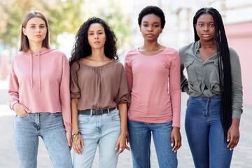 Multiracial group of millennial women in casual standing on the street, having strike. Young multiethnic ladies protestors fighting for women rights. Feminism, womens equality day concept