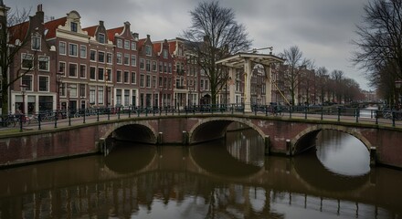 Obraz premium City Canal with Bridges and Traditional Buildings Under Cloudy Sky