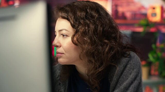 IT specialist at workstation programming on monitor and writing lines of code, using development tools and a terminal window interface. Woman debugging software before deadline. Camera B.
