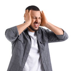 Young man suffering from loud noise on white background