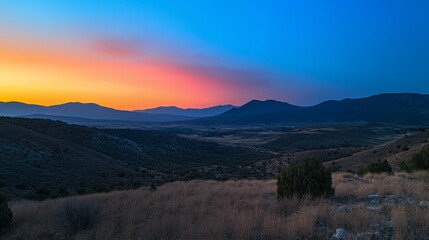 Breathtaking sunset over mountains with vibrant hues of orange and blue.