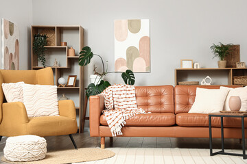 Armchair, comfortable sofa and coffee table in interior of living room