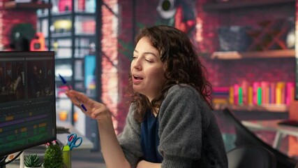 Video editors couple working as a team for a freelance video shoot, editing and mixing video clips in post production using filmmaking software. Talented people work on a music video. Camera B.