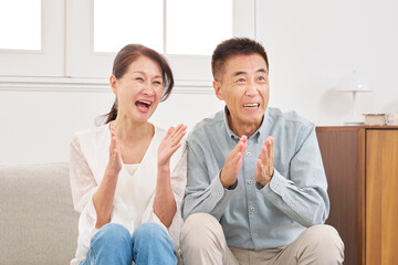 テレビを見るシニアの夫婦　リビング