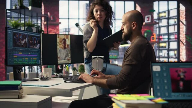 In a tech driven studio, team edits smartphone video footage on a dual monitors setup, applying professional tools for video creation. Targeting algorithm shifts and maximizing engagement. Camera A.