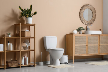 Interior of restroom with toilet bowl, sink and shelf unit