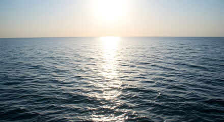 Obraz premium Golden Hour Reflections: Serene Ocean View at Sunset Over Calm Waters