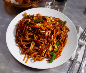 Popular Asian cuisine. Spicy stir fried noodles soba with vegetables, chicken and omelette