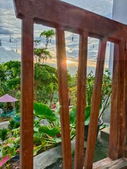Viewing Garden Sunset Through Wooden Railing Greenery and Sky