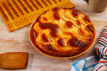Tasty pie with caramelized apples on orange plate