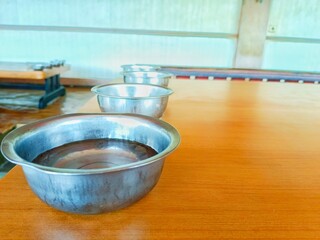Bowls with Liquid on Wooden Table in a Row