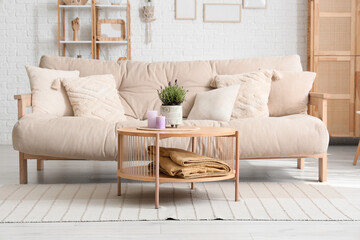 Lavender flowers and candles on table in living room interior