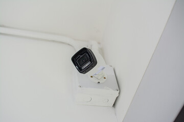 White security camera install on a white wall.