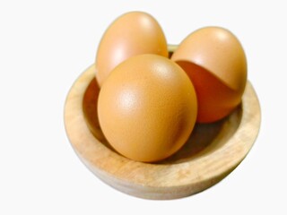 Three Eggs in Small Wooden Bowl on White Background