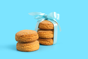Sweet cookies tied with ribbon on blue background