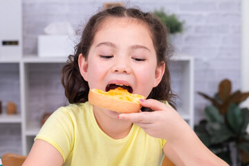 A cheerful girl in a bright room holding a slice of bread, showcasing a joyful and casual moment during a meal in a cozy indoor environment. Keywords highlight the mood and simplicity