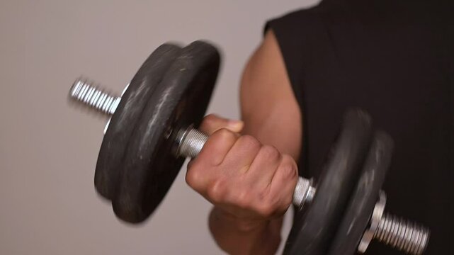 Close-up of man curl with dumbbell in supinated dumbbell position