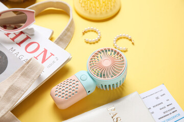 Female summer accessories, passport, ticket and mini fan on yellow background