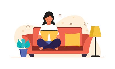 Woman sitting on sofa and working on her laptop