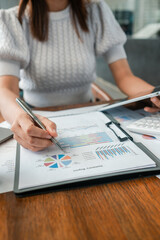 Professional woman reviewing financial documents and charts, highlighting business analysis and strategy.