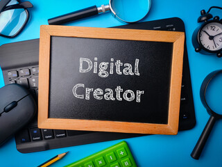 Top view wooden board and keyboard with the word Digital Creator on a blue background