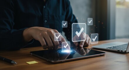 Person using tablet with check mark icons and laptop on desk in office space