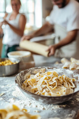 A bright kitchen with a bowl of fresh pasta in the center. A mother and father are rolling out dough while the kids prepare a sauce