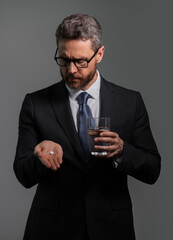 Man taking a medicine pill from headache migraine. Man with sinus headache, tension or cluster headache on gray studio. Migraine symptoms. Chronic headaches. Headache triggers.