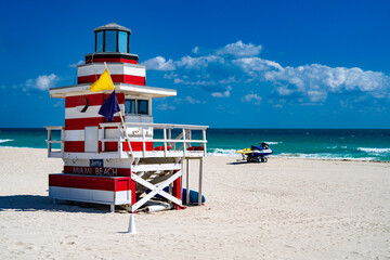 Fototapeta premium Miami Beach. Lifeguard tower on South Miami Beach. Miami Beach coastline. Famous Beach lifeguard. Travel to Miami. Art Deco lifeguard on Miamis shoreline. Jetty lifeguard tower.