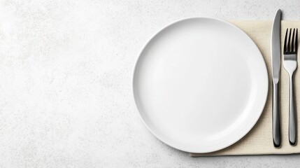 Empty white plate with cutlery on placemat overhead view