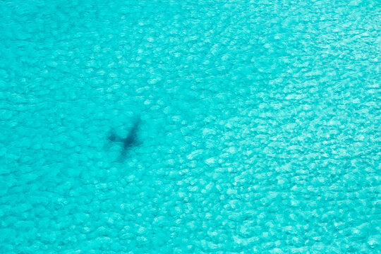 Airplane shadow over turquoise water in the caribbean sea, Mexico