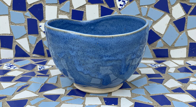 Handmade Blue Ceramic Bowl on Blue Mosaic Tile Background Artisan Pottery Craft - Powered by Adobe