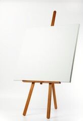 A small, empty, white canvas rests on a simple wooden easel. The studio setup is minimalist, isolated on white. Perfect for art projects