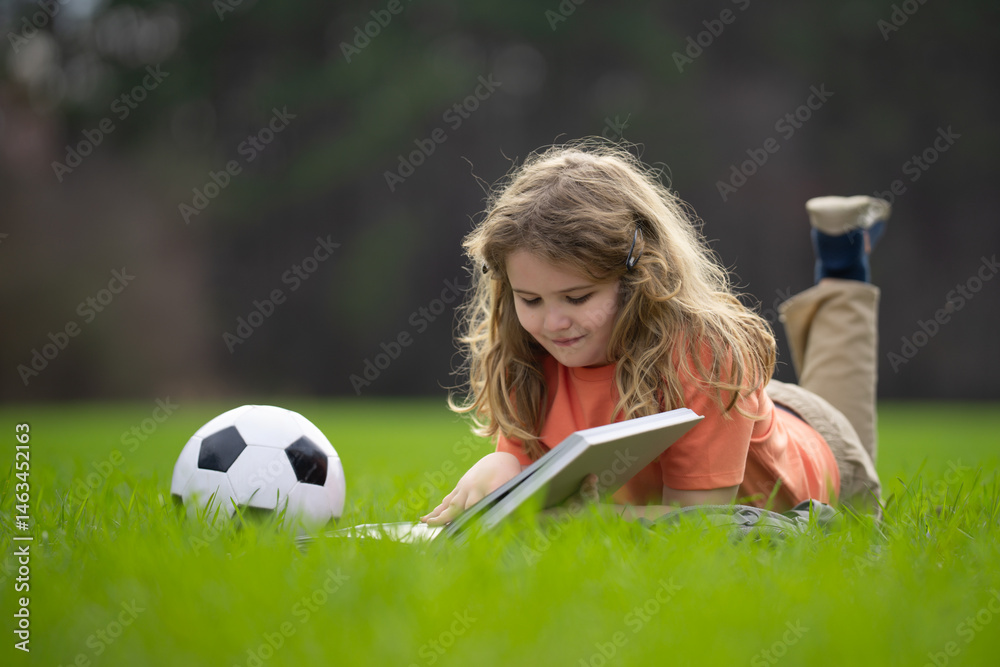 Poster child reading a book in the grass. kid enjoying a book story outdoors. child studying with book in t