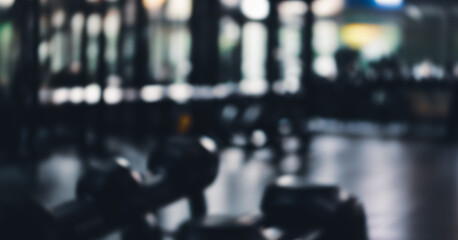 Fototapeta premium Out of focus gym interior with exercise equipment and mirrored wall.
