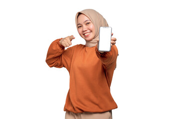 Excited young Asian woman in orange shirt showing mobile phone blank screen recommending App...