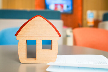 House model and bank book are placed on the table in the bank and thinking about applying for a home loan, placing collateral for the loan.