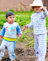 Two latin kids. Little girl holding a worm.